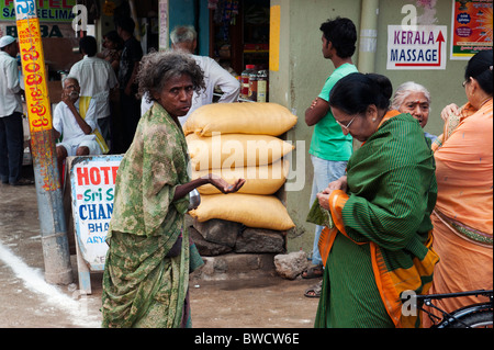 Lower caste indian woman begging on the street. Puttaparthi, Andhra Pradesh, India Stock Photo