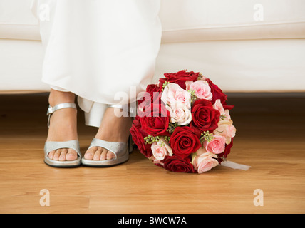 USA, Illinois, Metamora, Bride sitting on sofa beside bouquet Stock Photo