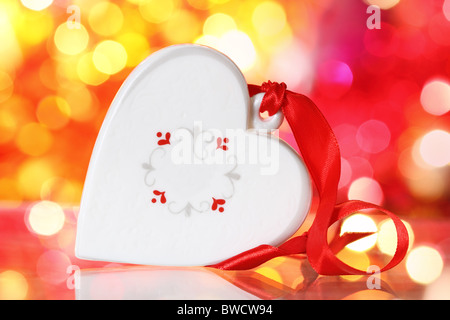 Christmas white heart with red ribbon against blurred background Stock Photo