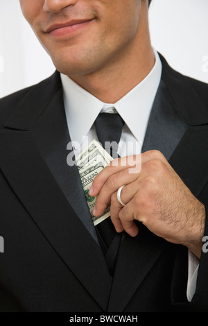 USA, Illinois, Metamora, Businessman taking out money from jacket Stock Photo