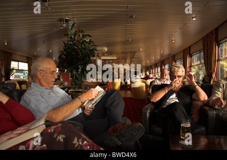 Passengers relaxing in the lounge on a river boat cruise, on the Rhine River, Germany Stock Photo