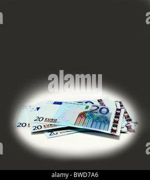 A pile of €20s in a spotlight, cut out. Stock Photo