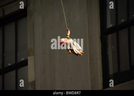 Doll hanging over a wire in Brooklyn NY Stock Photo