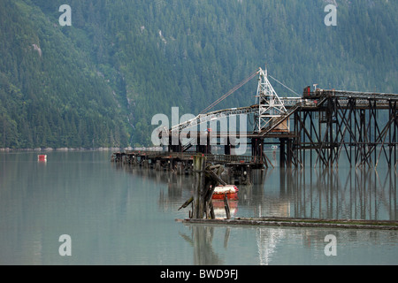 An abandoned industrial area sitting on pylons in a river. Stock Photo