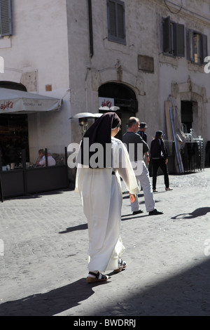 nun walking down Rome street Stock Photo