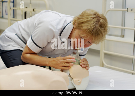 Nurse practises resuscitation on a dummy in a teaching hospital ward Stock Photo