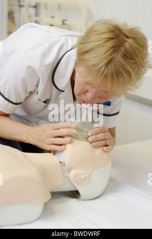 Nurse practises resuscitation on a dummy in a teaching hospital ward Stock Photo