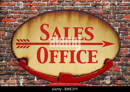 A rusty old retro arrow sign with the text Sales Office