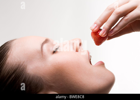 Image of pretty girl with open mouth and ripe strawberry in hand Stock Photo