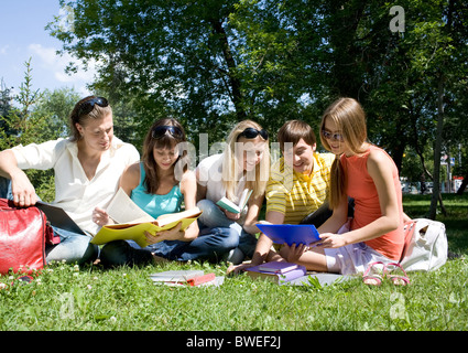 Portrait of busy students reading books in park together Stock Photo