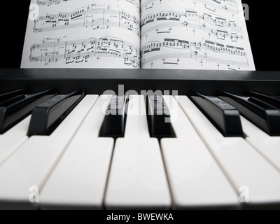 piano and the note sheets , focus on the black keys with notes reflection Stock Photo