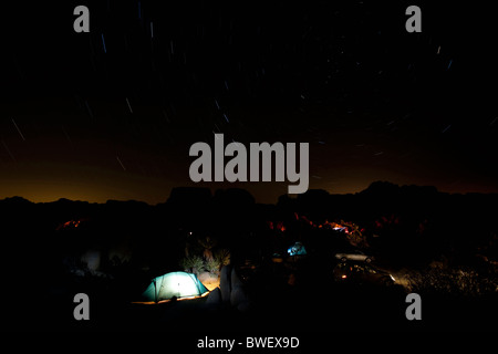 Tent illuminated from inside under starry sky at Joshua Tree National Park, California, USA Stock Photo