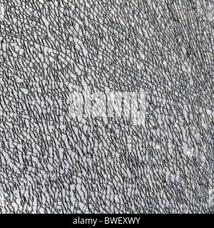 Close up of broken glass shattered window panel as abstract pattern background image manipulated London England UK