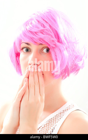 Young woman waring a purple wig with hands covering mouth Stock Photo