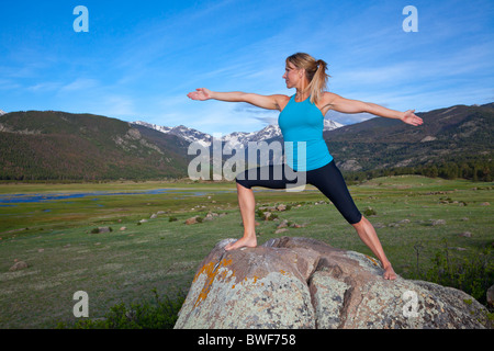 A beautiful woman practices yoga in the Rocky Mountains of Colorado Stock Photo