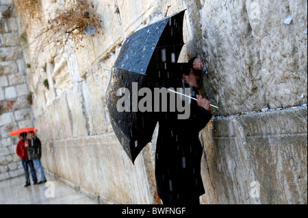 Religious Jews praying at the Western Wall in in the Old City of Jerusalem during a snow storm. Stock Photo