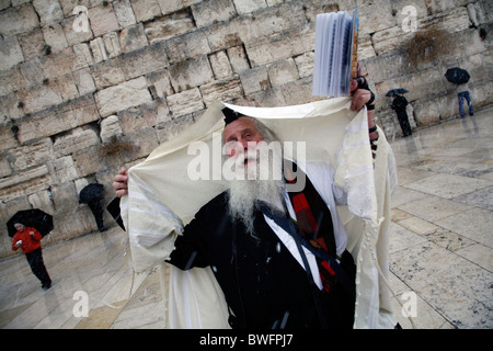 Religious Jew praying at the Western Wall in in the Old City of Jerusalem during a snow storm. Stock Photo