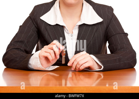 Business woman holds house key for handing over of keys. Isolated on white background. Stock Photo