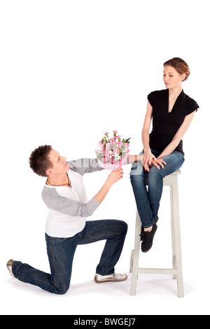 Man handing over bouquet of flowers to a beautiful young woman on Valentine Day isolated on white background Stock Photo