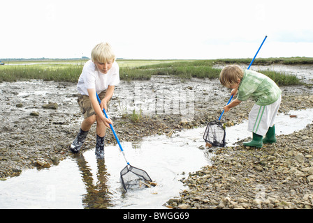 Two boys playiing in stream with nets Stock Photo