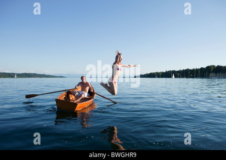 Young woman jumping off a row boat Stock Photo