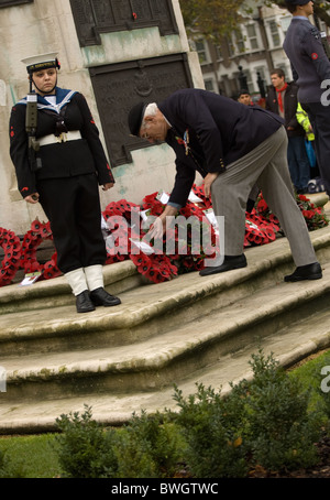 a member of the British legion lays a poppy wreath during remembrance day at East Ham Cenotaph central park Stock Photo