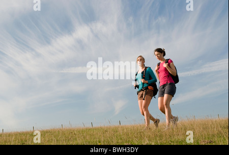 Female hikers walk on hill top