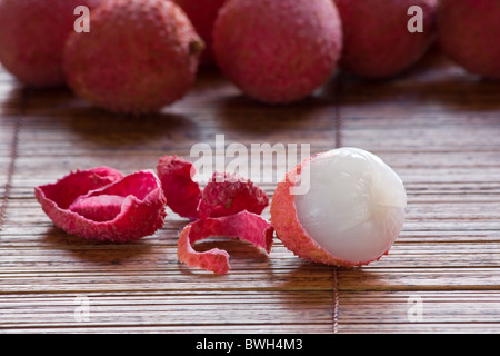 fresh peeled lychee pulp and whole lychees on elegant white serving ...