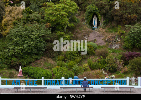 Pilgrim at Grotto of the Virgin Mary and The Immaculate Conception at Ballinspittle near Kinsale, County Cork, Ireland Stock Photo