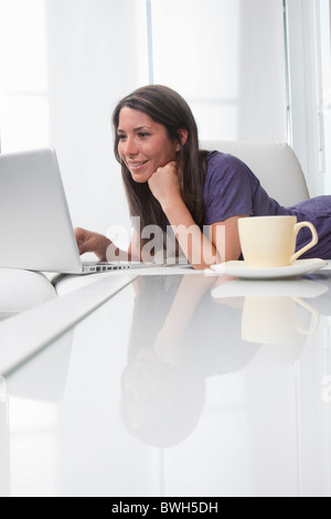 Young woman using laptop at home Stock Photo