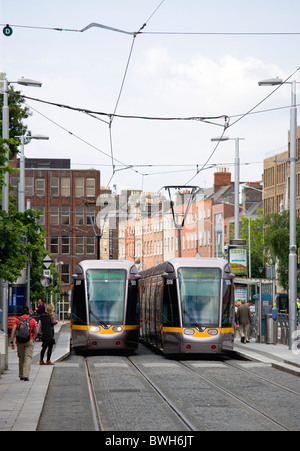Ireland, County Dublin, Dublin City, Luas light rail trams at stop beside Saint Stephen's Green with people. Stock Photo