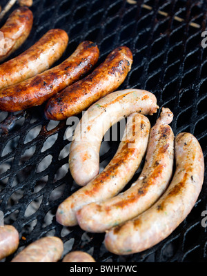 Food, Meat, Cooking, Sausages being cooked on a BBQ barbecue outdoor grill over hot coals. Stock Photo