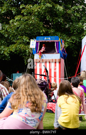 Children, Entertainment, Punch and Judy Show, Children sitting on grass watching the traditional puppet show. Stock Photo
