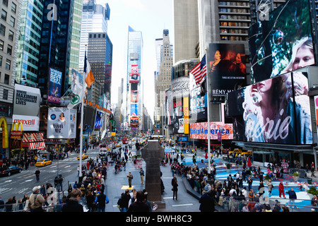 USA New York NYC Manhattan People walking in Times Square at the junction of 7th Avenue and Broadway below advertising screens Stock Photo