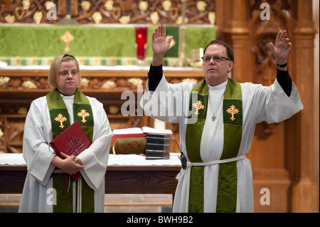 Anglo male minister and Anglo female assisting minister on pulpit during service at St. Martin's Lutheran Church in Austin, TX Stock Photo