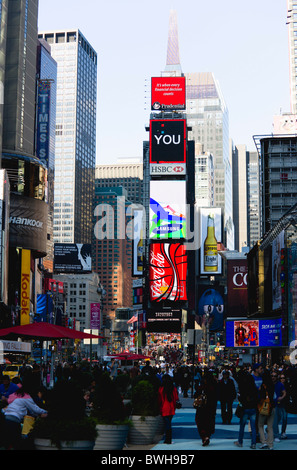 USA, New York, Manhattan, People walking in Times Square at the junction of 7th Avenue and Broadway below advertising screens Stock Photo