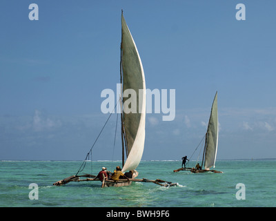 two fishing ngalawas (local dugout boats sometimes incorrectly called Dhows) sailing in the Indian Ocean off Matemwe Zanzibar in full sail Stock Photo