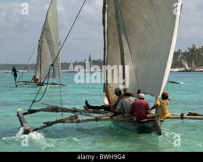 fishing ngalawas  incorrectly called Dhows sailing off Matemwe Zanzibar one sailor balancing on outrigger others reclining Stock Photo