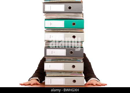 Desperate business woman sits behind folder stack. Isolated on white background. Stock Photo