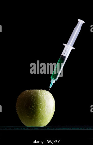 Syringes stuck in an apple Stock Photo