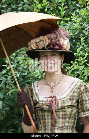 Lady dressed in proper American late 1800s early 1900s dress and umbrella Stock Photo
