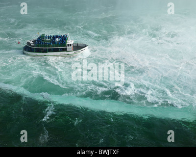 People on Made of the Mist boat ride approaching Niagara Falls Horseshoe edge Stock Photo