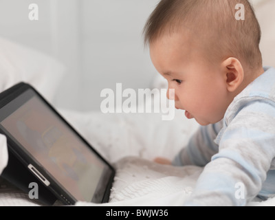 Six month old baby boy playing with Apple iPad tablet computer Stock Photo