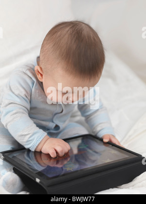 Six month old baby boy playing with Apple iPad tablet computer Stock Photo