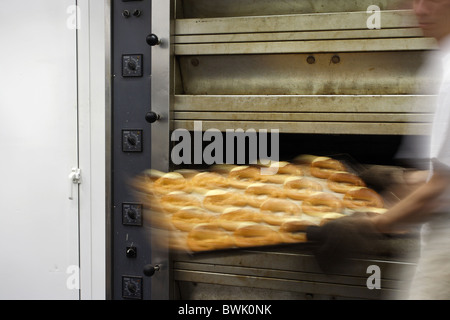 A baker taking a tray of pretzels out of a deck oven, Conil de la Frontera, Spain Stock Photo