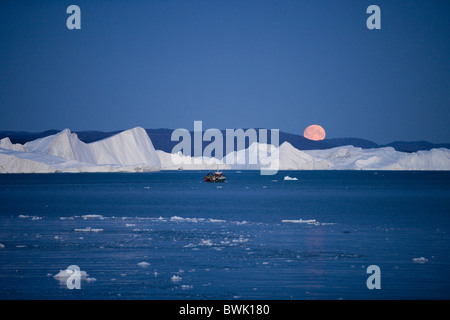 Full moon rising over icebergs from Ilulissat Kangerlua Icefjord at dusk, Ilulissat (Jakobshavn), Disko Bay, Kitaa, Greenland Stock Photo