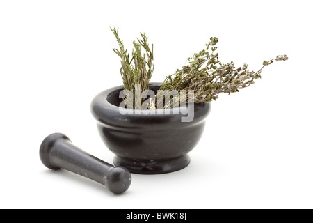 Different dried herbs in stone mortar over white background Stock Photo