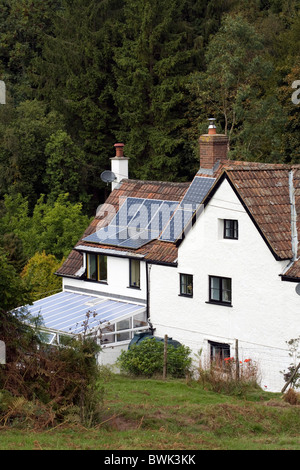 A cottage fitted with solar panels in The Forest of Dean Gloucestershire England Stock Photo