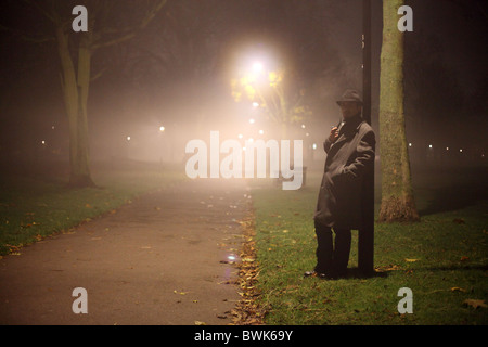 man with trench coat and hat in the park Stock Photo