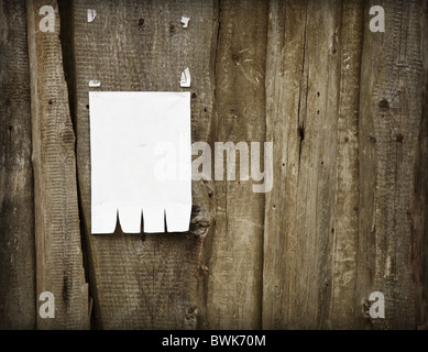Paper advertisement is fixed to a wooden fence Stock Photo